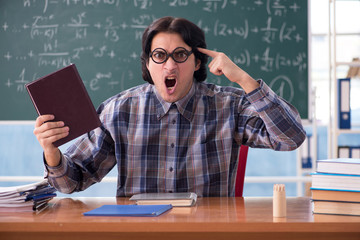 Young funny math teacher in front of chalkboard 