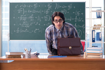 Young funny math teacher in front of chalkboard 