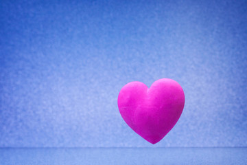 Plain blue background with little violet red heart