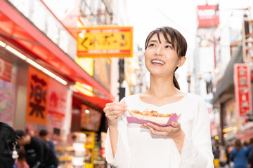 大阪でたこ焼きを食べる女性