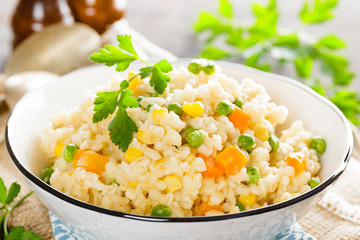 Bulgur wheat boiled with carrot, green peas and corn, healthy vegan diet