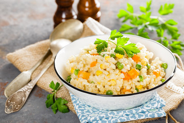 Bulgur wheat boiled with carrot, green peas and corn, healthy vegan diet