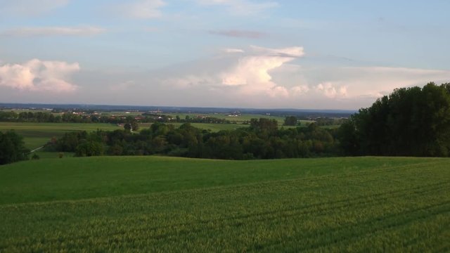 Aerial of a landscape in the sunset with villages and field in the foreground and trees in bavaria germany