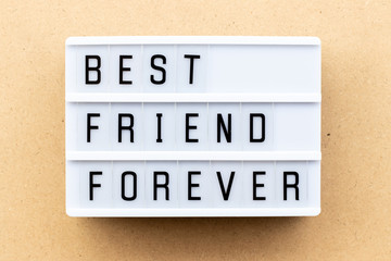 Light box with word best friend forever on wood background