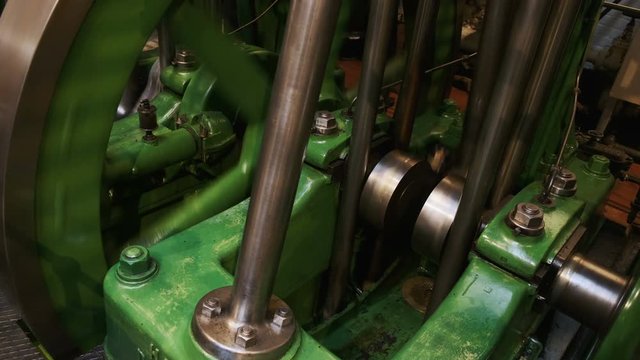 Close-up shot of a flywheel of a single cylinder industrial steam engine in operation