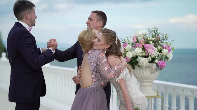 Guests at the wedding congratulate the bride and groom at the wedding ceremony. A young couple in love stands at the arch. Wedding by the sea.