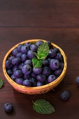 Fresh Blueberries in a basket on dark moody background, selective focus