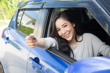 Happy young Asian woman holding payment card or credit card and used to pay for gasoline, diesel, and other fuels at gas stations, Driver with fleet cards for refueling car