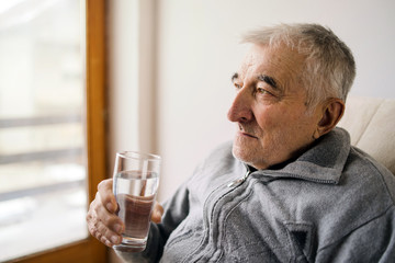 Portrait of senior man holding a glass of water