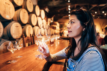 Happy young asian lady tasting wine