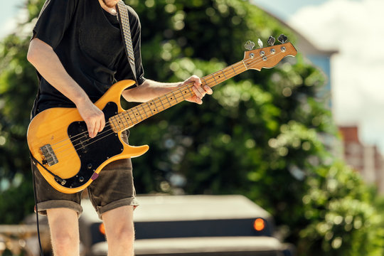 Close-up of bassist playing at an outdoor show