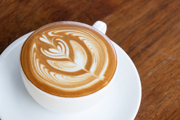 Coffee cup with latte art foam on wood table in coffee shop with copy space.Coffee is one of the most popular beverages.Improve Energy Levels and Burn Fat