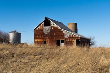 Fototapeta na wymiar Old rustic barn in the rural Midwest on a windy Winter's day. Marshall County, Illinois, USA