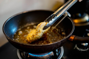 Cooking fried Japanese pork Tonkatsu homemade cutlet, during cook on heat oil on pan.