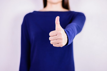 Woman in blue dress  giving thumb up.
