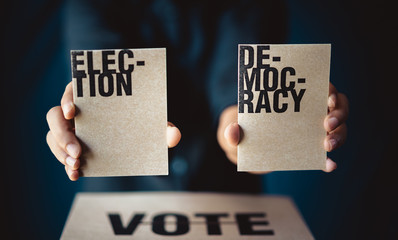 hand holding election card and vote box, democracy concept, retro tone