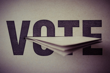 brown paper insert in vote box, selective focus, retro tone, democracy concept