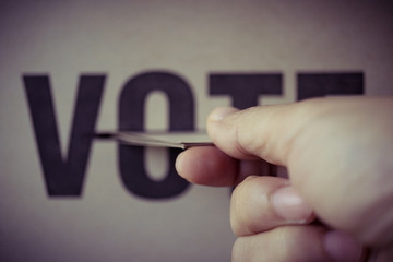 brown paper insert in vote box, democracy concept, retro tone