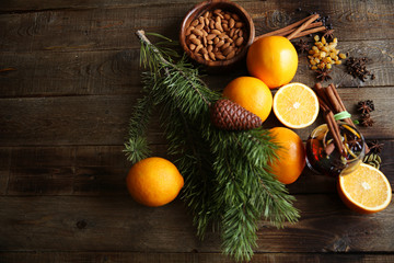 christmas still life with oranges, almonds,  and cinnamon on a wooden background, with a spruce branch with space for text