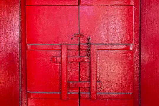 Antique red wooden door latch. Is a traditional way to lock Thai temple doors