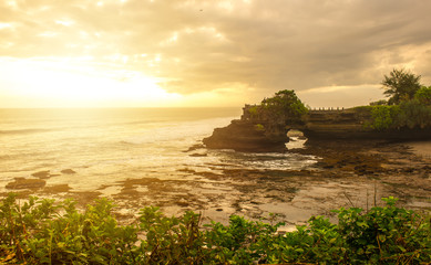 Beautiful sunset view of Pura Batu Bolong an iconic Hinduism sea temple nearly Tanah Lot temple in Bali island of Indonesia.