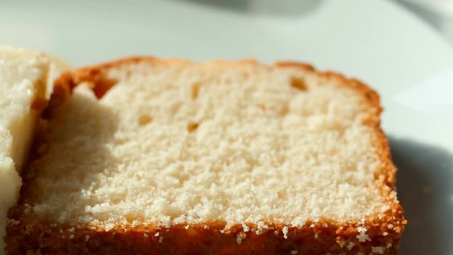 Close-up panning shot of slices of yoghurt cake with coconut, cheesecake with raisins and flan pudding at a breakfast table