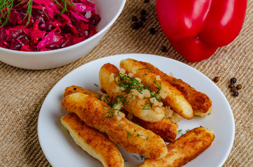 Breaded cheese and kefir sticks. Made from cheese, flour and kefir. Served with red salad.