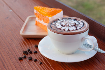 Coffee in a white coffee cup with Orange cake 
