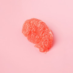 Red Grapefruit piece on pastel pink background. Minimal healthy fresh fruit. Grapefruit succulent pulp. Pantone treendy color of year 2019 Living Coral minimal fashion concept. Copy space for text.