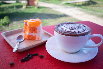 Coffee in a white coffee cup with Orange cake 
