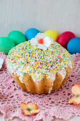 Easter cake on a table on a pink napkin and colorful eggs