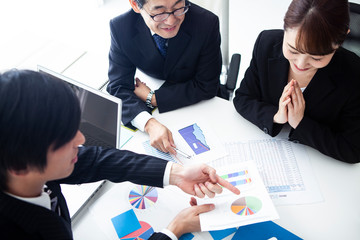 円グラフをみながら意見を交し合う会社員