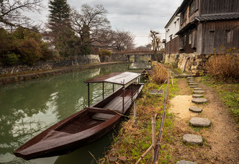 Wooden boat anchored alongside stone path in old Japanese village