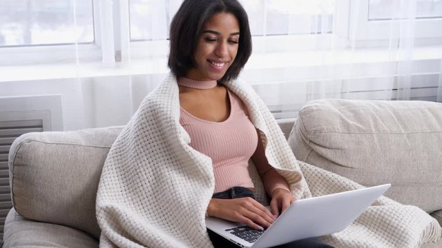 Teenage girl with laptop on sofa