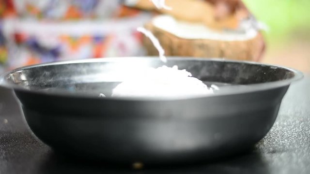 Woman making grate coconut and put it into bowl prepare for making Thai dessert