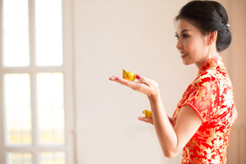 Chinese new year concept , Asian woman in chinese dress traditional cheongsam with gesture of congratulation