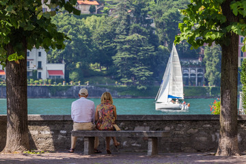 Old couple sitting in front of the lake