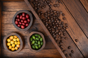 Coffee beans and fresh berries beans on wooden background