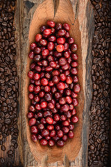 Coffee beans and fresh berries beans on wooden background