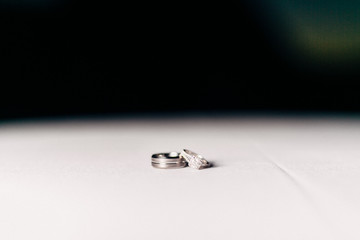 closeup of bride and groom rings on table