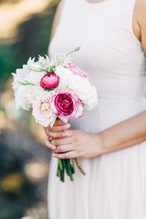 bride in wedding dress holding beautiful bouquet of flowers