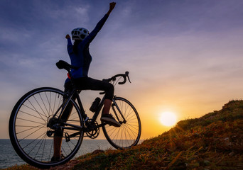 Cyclist riding mountain bike on the rocky trail at sunset.