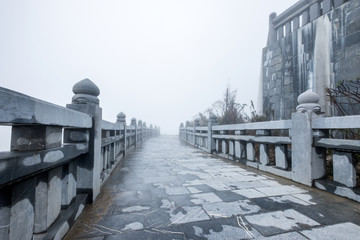 Obraz premium Stone rail and walkway with misty on hill