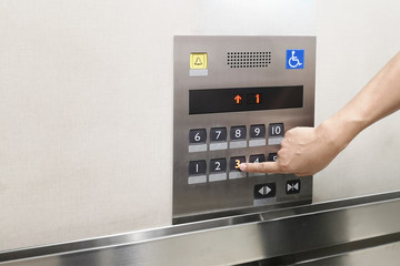 Men's hand with the press of control buttons interior elevator have braille panel for the disabled .