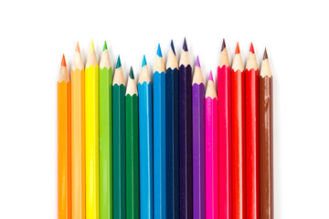 Colour pencils on white background, top view.