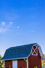 red barn during daytime with moon above