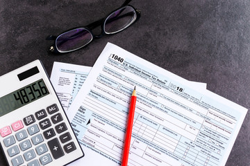 United States federal income tax return IRS 1040 documents, with pencil, calculator and eyeglasses