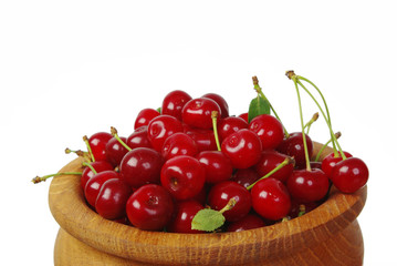 Cherry berries in a wooden pot. Close-up. Isolated on white