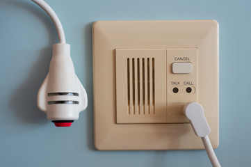 Nurse call system for emergency situation..Wall type and remote red emergency call button install in hospital patient room on pale blue background,healthcare concept..