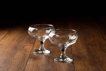 empty glass cups on a brown wooden background, tableware.